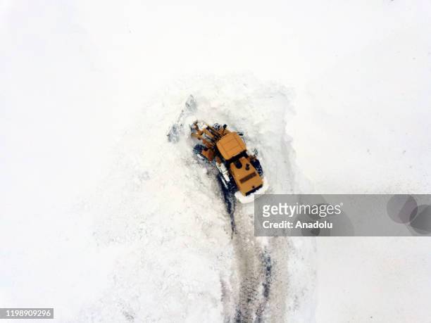 An aerial view of workers using a heavy machine to clear huge masses of snow from the streets in Turkey's eastern Mus province on February 06, 2020....