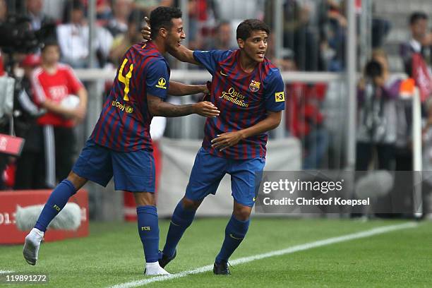 Jonathan Dos Santos of Barcelona celebrates the second goal with Thiago Alcantara during the Audi Cup match between FC Barcelona and International de...
