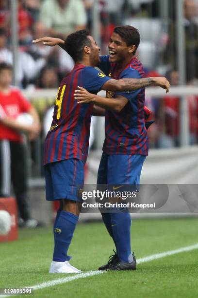 Jonathan Dos Santos of Barcelona celebrates the second goal with Thiago Alcantara during the Audi Cup match between FC Barcelona and International de...