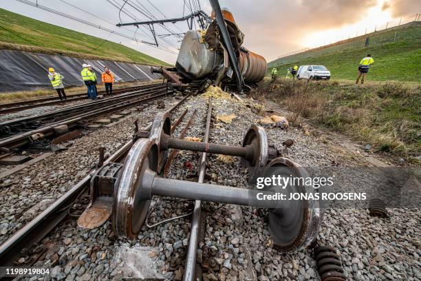 Staff members of Railway Infrastructure company Infrabel stands next to the wreckage of a derailed train occurred in the port of Antwerp, on February...