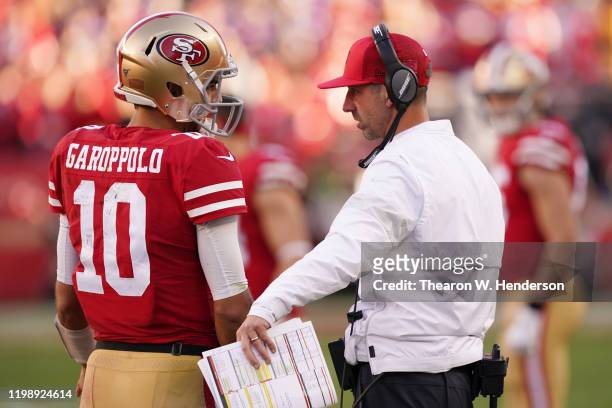 Jimmy Garoppolo speaks with head coach Kyle Shanahan of the San Francisco 49ers during the NFC Divisional Round Playoff game against the Minnesota...
