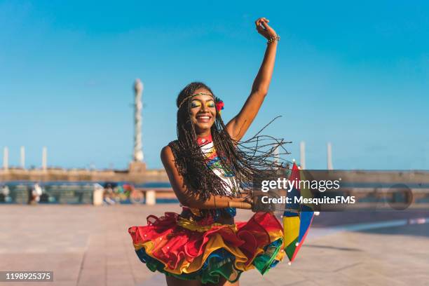 afro dancer holding a frevo umbrella in marco zero - recife estado de pernambuco - fotografias e filmes do acervo