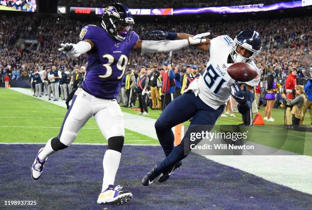 Jonnu Smith of the Tennessee Titans catches a touchdown over Brandon Carr of the Baltimore Ravens in the first quarter of the AFC Divisional Playoff...