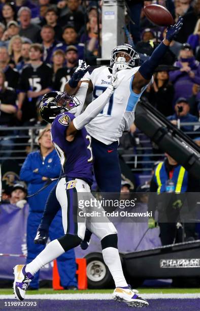 Jonnu Smith of the Tennessee Titans catches a touchdown over Brandon Carr of the Baltimore Ravens in the first quarter of the AFC Divisional Playoff...