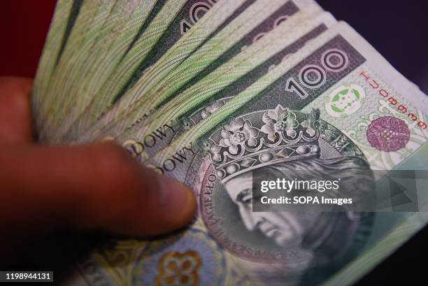 In this photo illustration 100 Polish Zloty banknotes seen displayed.