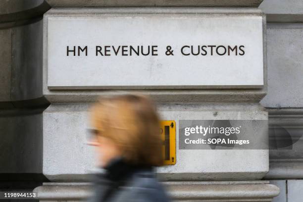 Woman walks past HM Revenue & Customs building on Whitehall in London.