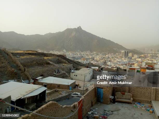 modern mecca (makkah) city view from the side of old and broken buildings - saudi arabia city stockfoto's en -beelden