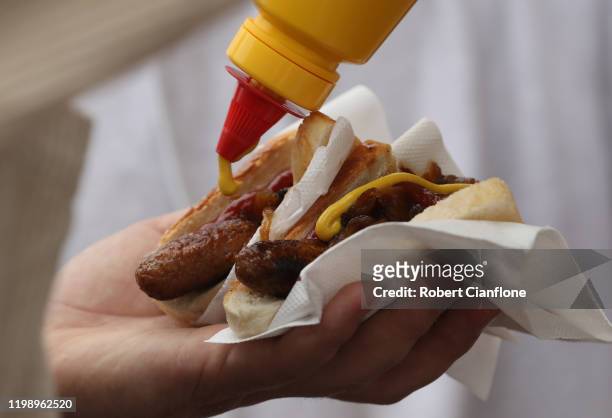 Patron puts mustard on their sausages 'Grill for Good' on January 12, 2020 in Melbourne, Australia. The event was raised by local musicians to help...