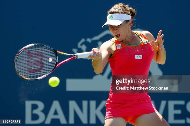 Simona Halep of Romania returns a shot to Sabine Lisicki of Germany during the Bank of the West Classic at the Taube Family Tennis Stadium on July...