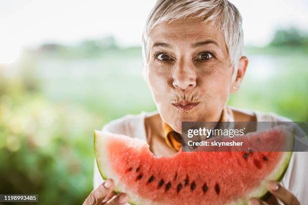 seniorin genießen beim essen frische wassermelone. - kauen stock-fotos und bilder