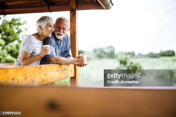 happy senior couple enjoying in morning coffee on a terrace. - coffee on patio stock pictures, royalty-free photos & images