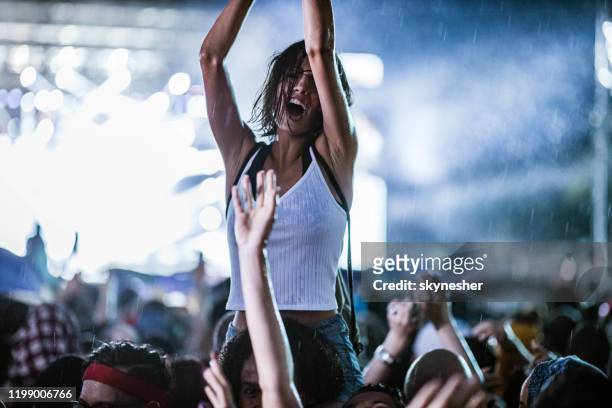 dancing on music festival during rainy night! - carrying on shoulders stock pictures, royalty-free photos & images