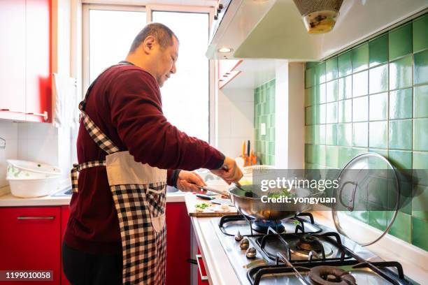 asiatischer mann kocht zu hause - gas cooking stock-fotos und bilder