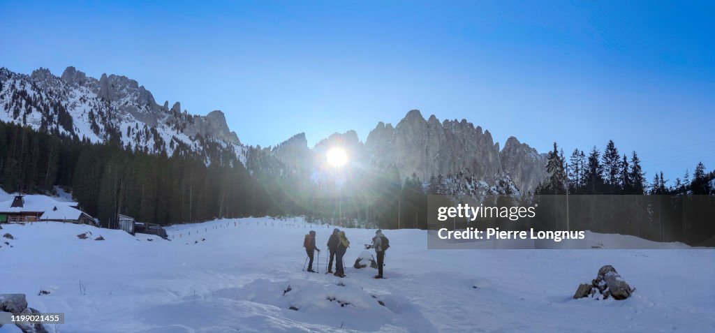 Sun rays passing through the "Grossmutterloch" (or Grandmother's Hole) - Non recognizable Snowshoe Hikers attending the phenomenon
