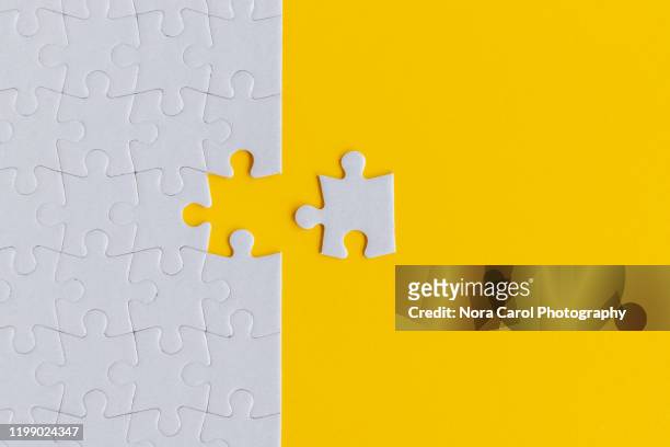jigsaw puzzle on yellow background - partnership teamwork stock-fotos und bilder