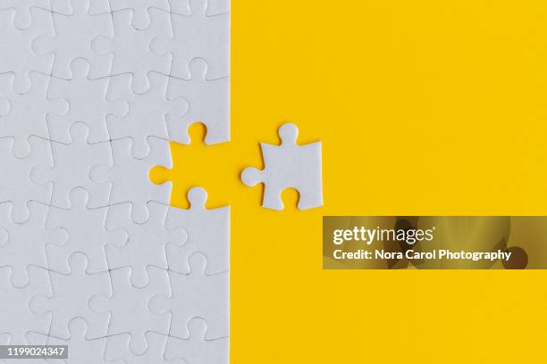 jigsaw puzzle on yellow background - puzzel stockfoto's en -beelden