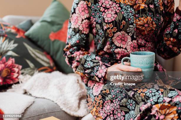 frau trinkt kaffee in blumenkleid - floral pattern dress stock-fotos und bilder