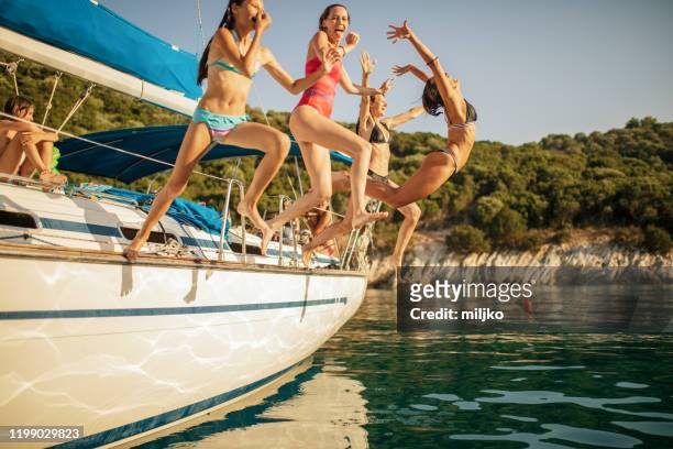 mensen genieten van vakantie op zeilboot - young girl swimsuit stockfoto's en -beelden