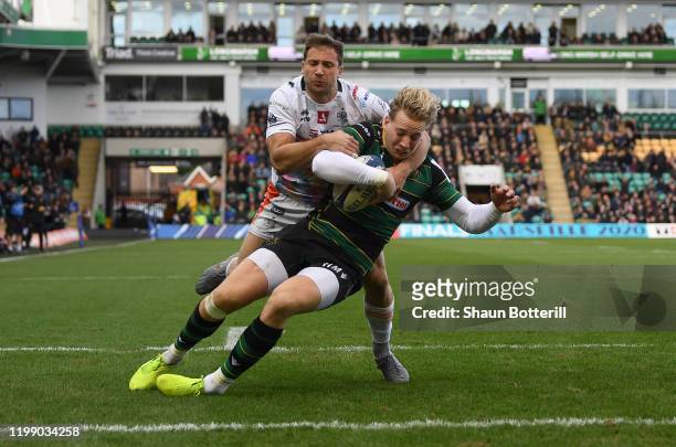 Harry Mallinder of Northampton Saints breaks the tackle of Tommaso Benvenuti of Benetton Rugby to score the first try during the Heineken Champions...
