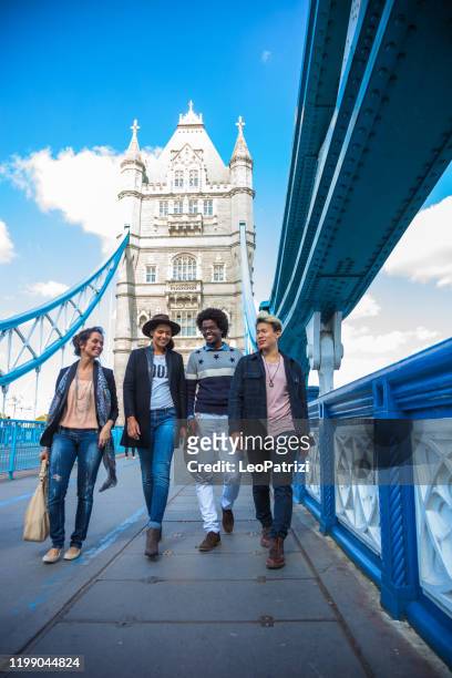 multi cultural group of friends hanging out in central london, on the tower bridge. - london landmark stock pictures, royalty-free photos & images