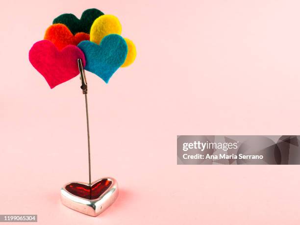 a heart-shaped ornament and a clip with several felt colored hearts. polyamory concept - polygamy ストックフォトと画像