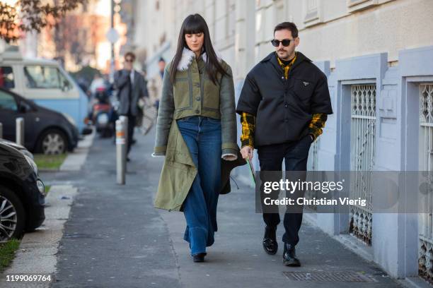 Laura Comolli is seen wearing flared denim jeans, green ripped off coat and Roberto De Rosa wearing Prada jacket outside MSGM during Milan Fashion...