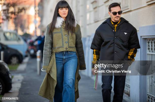 Laura Comolli is seen wearing flared denim jeans, green ripped off coat and Roberto De Rosa wearing Prada jacket outside MSGM during Milan Fashion...