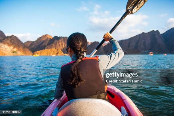 vrouw kajakken in een meer close-up - oman stockfoto's en -beelden