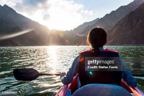 woman kayaking in hatta lake in dubai at sunset - kayak stock pictures, royalty-free photos & images