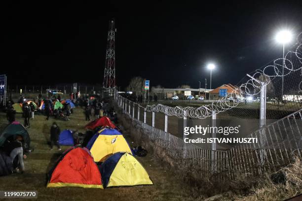 Migrants camp in tents next to the border fence at the Serbian Kelebija border village near Subotica on February 6 as the Tompa road border-crossing...