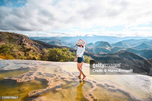 woman walking on the limestone rock formations at hierve el agua, oaxaca, mexico - hispanoamérica fotografías e imágenes de stock