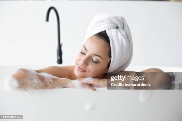 woman relaxing in bathtub - domestic bathroom stock pictures, royalty-free photos & images