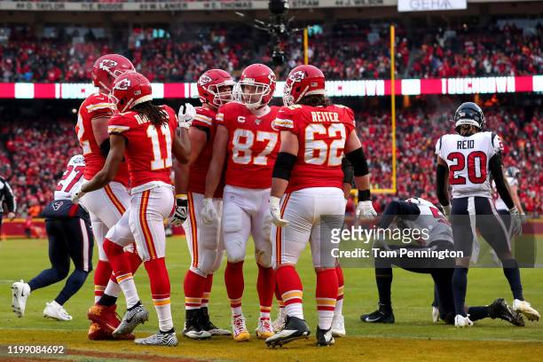 Travis Kelce of the Kansas City Chiefs is congratulated by his teammates Eric Fisher after his third touchdown reception of the second quarter...