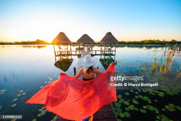 woman playing with red sarong on a pier, mexico - beautiful mexican women stock-fotos und bilder