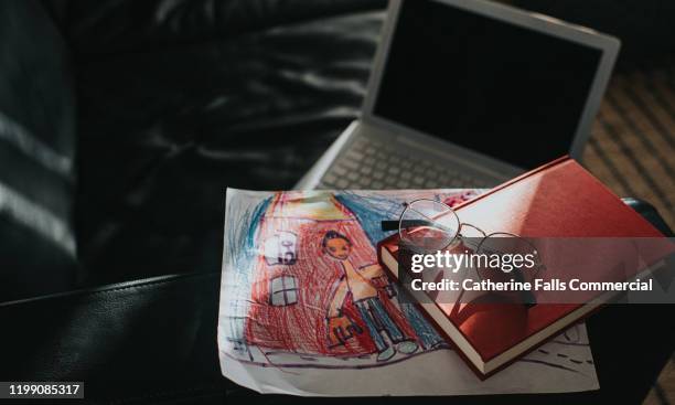 book, laptop and kids artwork - bezittingen stockfoto's en -beelden