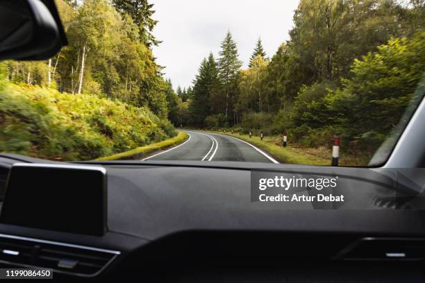 driving in mountain road with wet asphalt and curve from passenger view. - car interior stock pictures, royalty-free photos & images