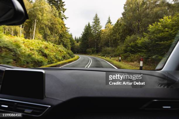 driving in mountain road with wet asphalt and curve from passenger view. - dashboard vehicle part imagens e fotografias de stock