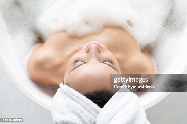 young pretty woman taking shower - hot tub bubble bath stock pictures, royalty-free photos & images