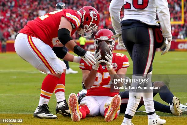 Travis Kelce of the Kansas City Chiefs is congratulated by his teammates Eric Fisher after his third touchdown reception of the second quarter...