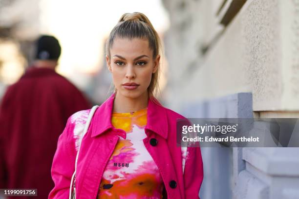 Jessica Goicoechea wears a pink and white long coat, a pink orange and yellow tie-dye MSGM body suit, outside MSGM, during Milan Fashion Week...