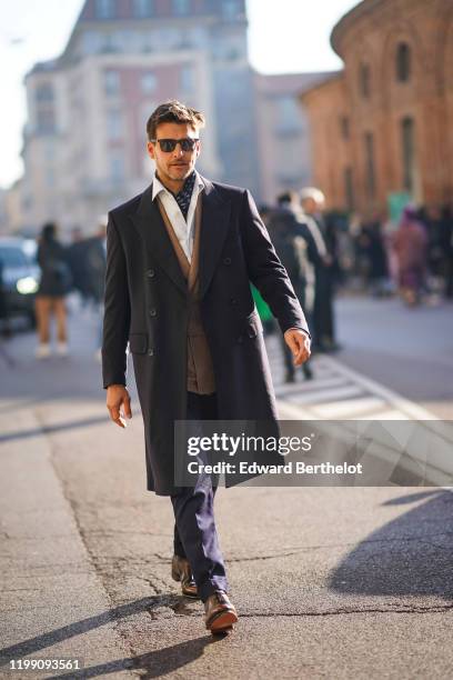 Johannes Huebl wears sunglasses, a scarf, a white shirt, a light brown blazer double breasted jacket, black pants, a black coat, leather shoes,...