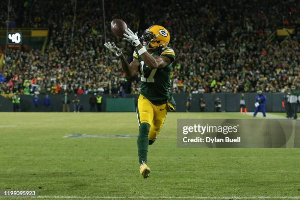 Davante Adams of the Green Bay Packers makes a touchdown catch against the Seattle Seahawks in the first quarter of the NFC Divisional Playoff game...