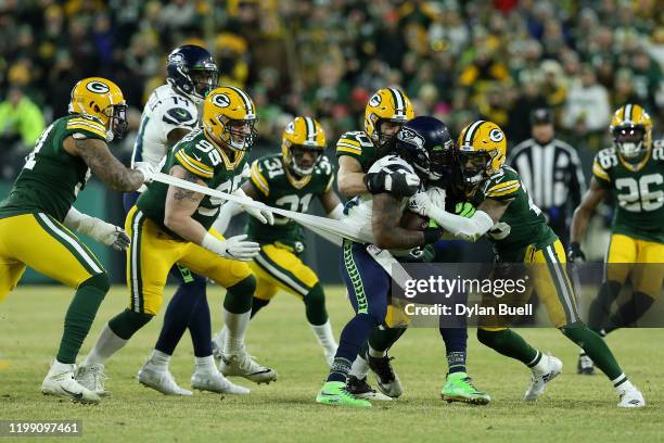 Blake Martinez, Jaire Alexander of the Green Bay Packers tackle Marshawn Lynch of the Seattle Seahawks as Preston Smith of the Green Bay Packers...