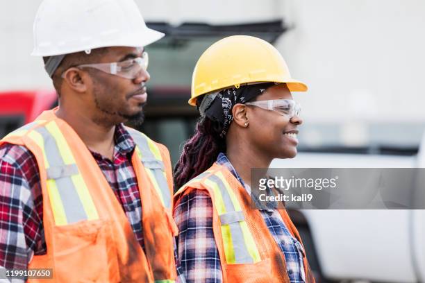 female construction worker and coworker wearing hardhats - confident young man at work stock pictures, royalty-free photos & images