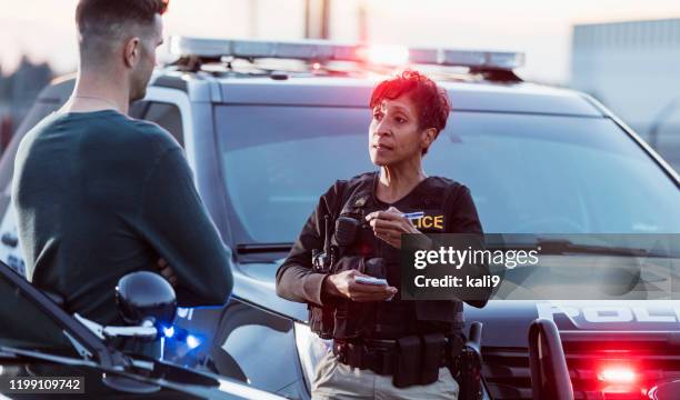 policewoman taking a statement from young man - black police stock pictures, royalty-free photos & images