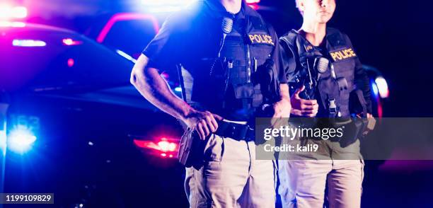 two police officers standing in front of patrol cars - maritime police stock pictures, royalty-free photos & images