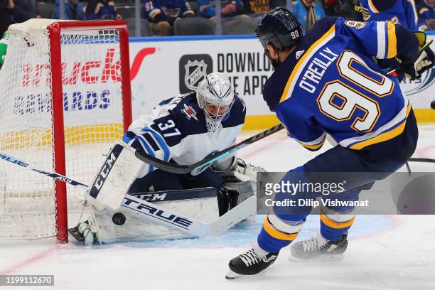 Connor Hellebuyck of the Winnipeg Jets makes a save against Ryan OReilly of the St. Louis Blues at the Enterprise Center on February 6, 2020 in St....