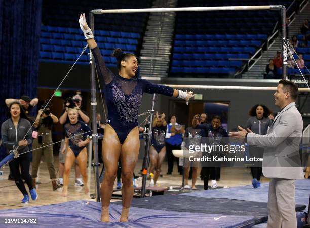 Kyla Ross of UCLA and head coach Chris Waller celebrate after competing on the uneven parallel bars during a meet against Boise State at Pauley...