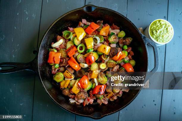 mediterranean style vegetable medley in a cast iron skillet including brussels sprouts, bell pepper, onion, bacon - salteado imagens e fotografias de stock