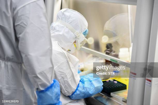 This photo taken on February 6, 2020 shows a laboratory technician working on samples from people to be tested for the new coronavirus at "Fire Eye"...